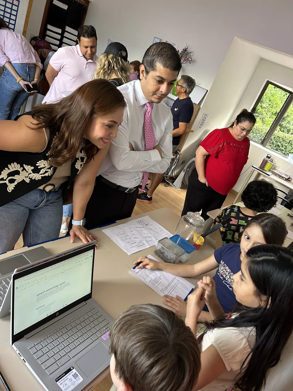 An Acton Academy El Salvador learner in shirt and tie presenting work to visiting professionals