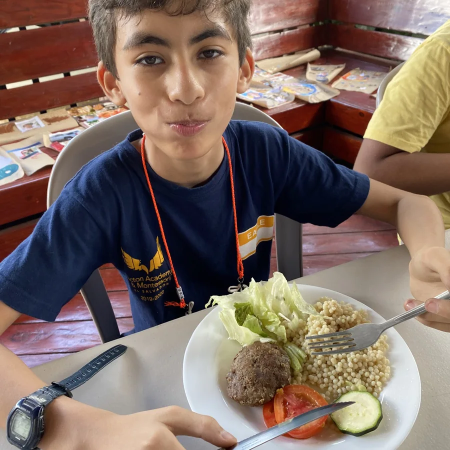 A learner at Acton Academy El Salvador eating a homemade lunch from a real ceramic plate with real cutlery