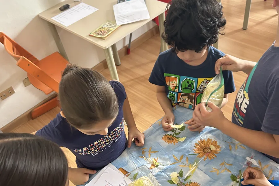 Learners working together at their own table and clearing up after themselves at Acton Academy El Salvador