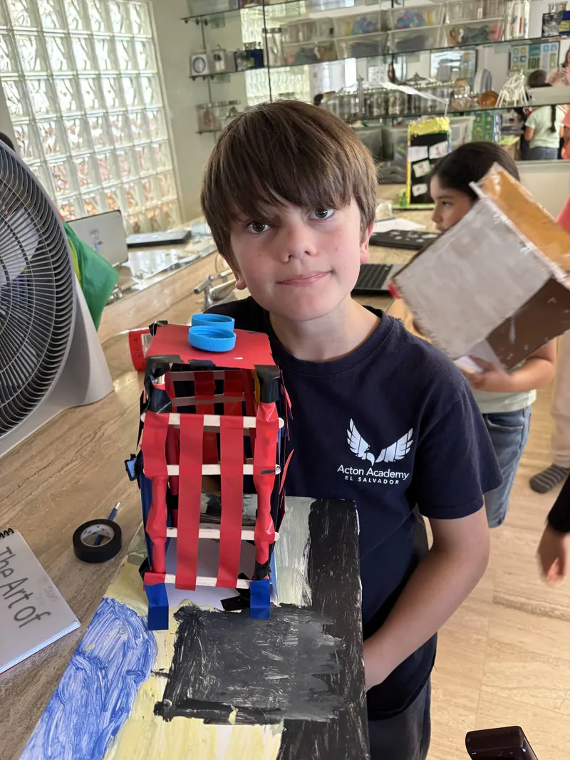 A learner holding a machine he designed and built himself