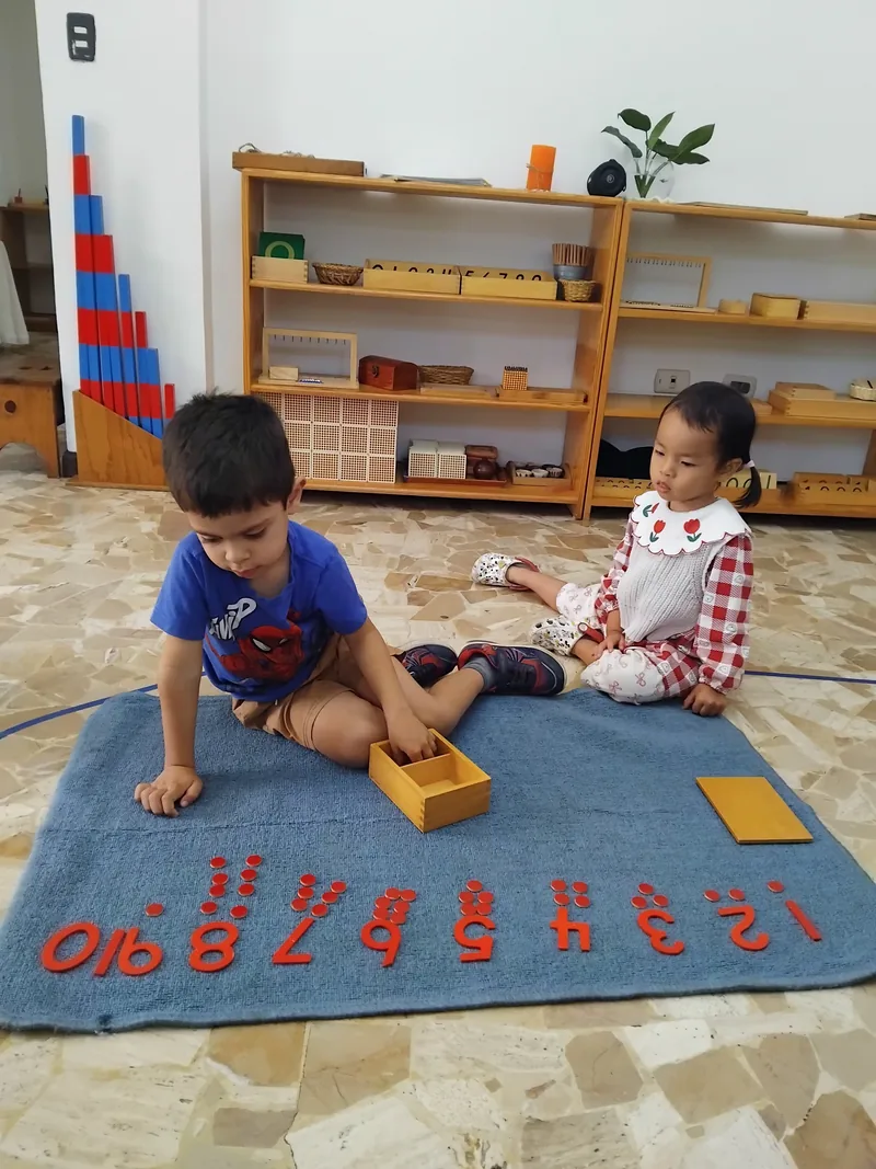 Two of our youngest children laying out the numerals on a work mat