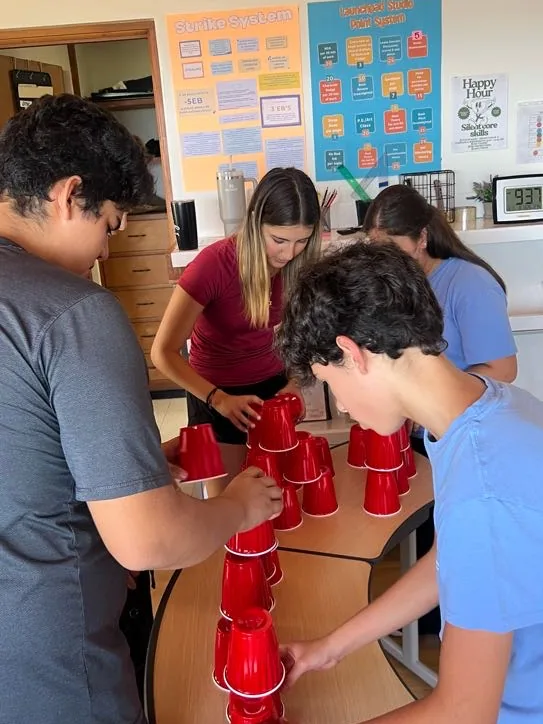 Learners and a guide building a tower together in a team challenge