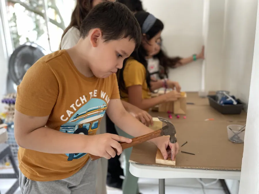 A learner building with wood and real tools at Acton Academy El Salvador